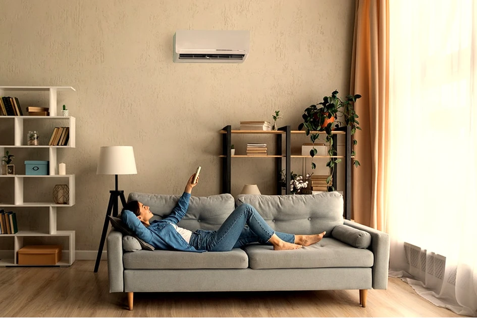 personne utilisant une télécommande pour régler sa climation réversible